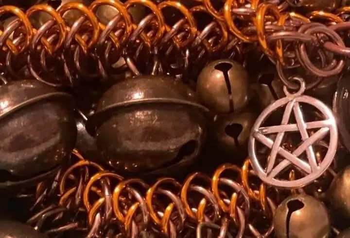 Jewelry pliers, metal rings, and chainmaille tools laid on a work surface.